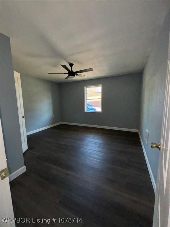 spare room featuring dark hardwood / wood-style floors and ceiling fan