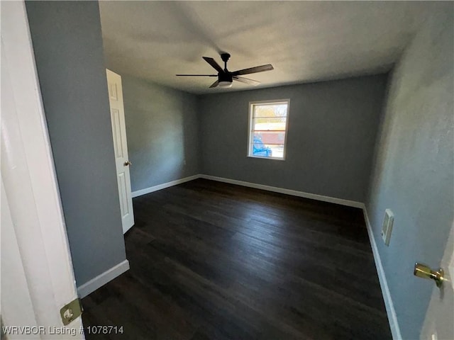 unfurnished room featuring dark wood-type flooring and ceiling fan