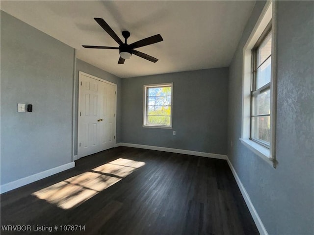 unfurnished bedroom featuring dark wood-type flooring and ceiling fan