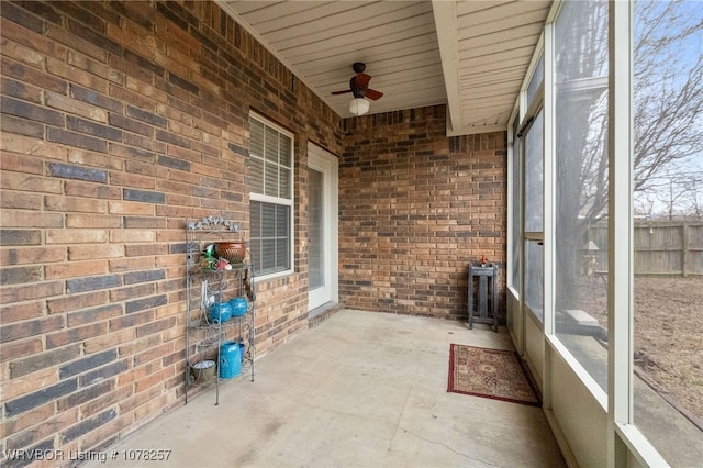 unfurnished sunroom featuring ceiling fan