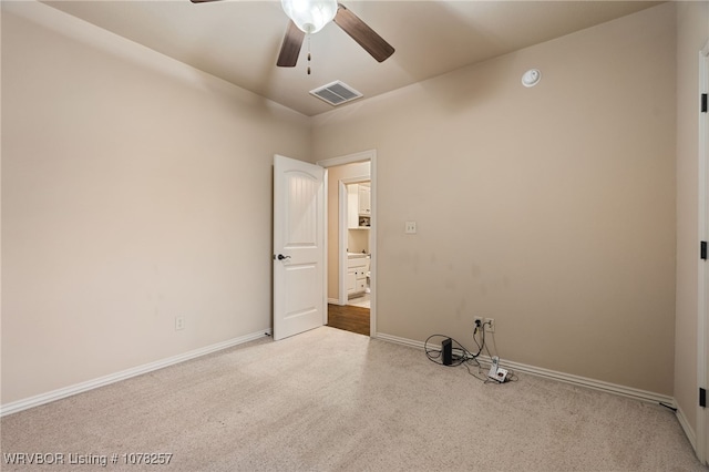 unfurnished room with light colored carpet and ceiling fan