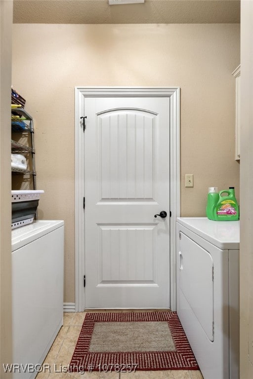 laundry room with washing machine and dryer and light tile patterned floors