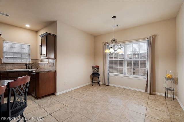 kitchen with dark brown cabinetry, decorative backsplash, sink, and light tile patterned flooring