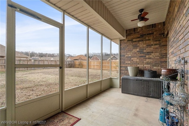 unfurnished sunroom with ceiling fan