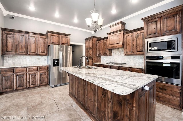 kitchen featuring appliances with stainless steel finishes, a center island with sink, a notable chandelier, and sink