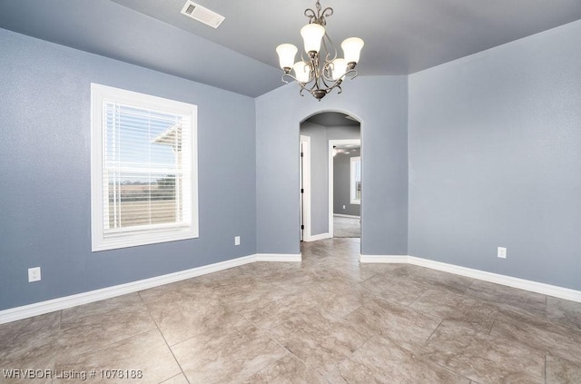 spare room with an inviting chandelier