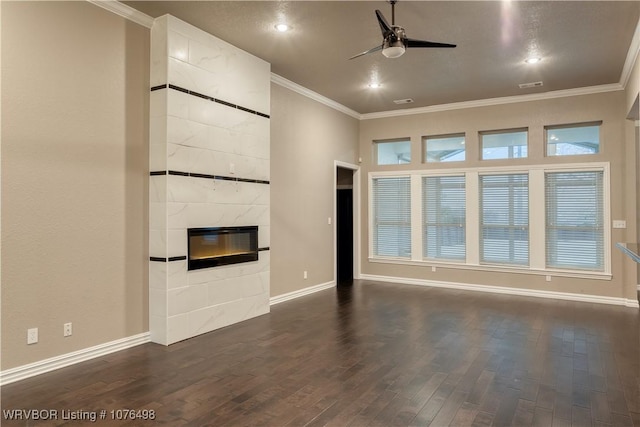 unfurnished living room featuring crown molding, dark wood finished floors, a fireplace, and ceiling fan