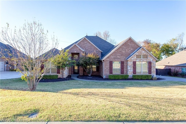 view of front facade with stone siding, a front lawn, and brick siding