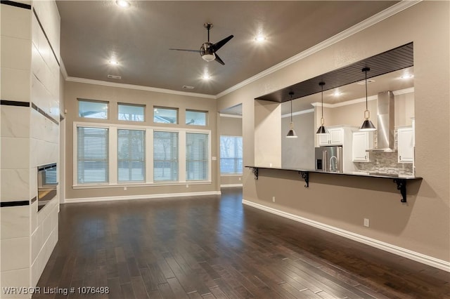 unfurnished living room with a ceiling fan, baseboards, ornamental molding, and dark wood-style flooring