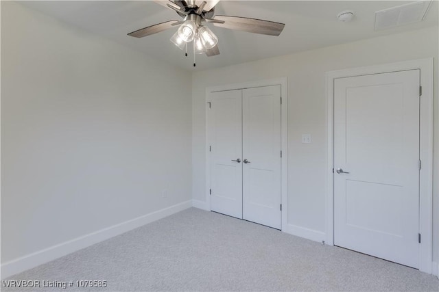 unfurnished bedroom featuring light carpet, baseboards, visible vents, and a closet