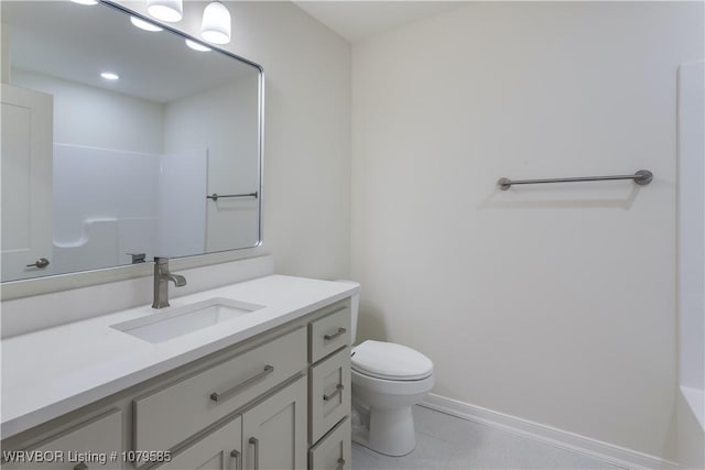 bathroom featuring baseboards, toilet, and vanity