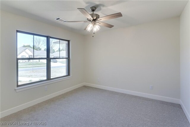unfurnished room featuring light carpet, baseboards, ceiling fan, and visible vents