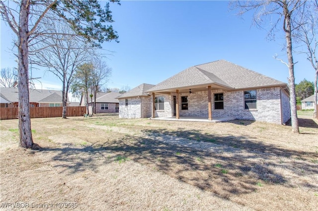 back of property featuring fence, a patio, ceiling fan, brick siding, and a shingled roof