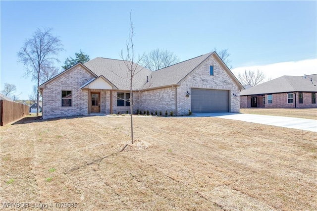 view of front facade featuring fence, driveway, a front lawn, brick siding, and a garage