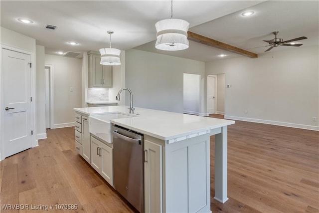 kitchen featuring light countertops, a center island with sink, a sink, light wood-style floors, and dishwasher