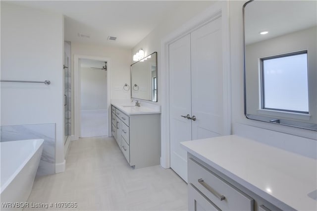 full bathroom with visible vents, a freestanding tub, a ceiling fan, vanity, and a stall shower