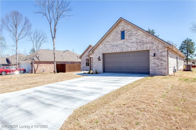 view of front of property featuring cooling unit, a garage, brick siding, and concrete driveway