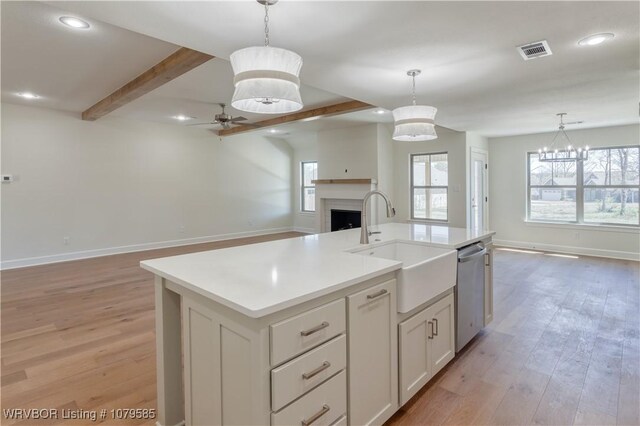 kitchen featuring visible vents, beamed ceiling, a ceiling fan, open floor plan, and stainless steel dishwasher