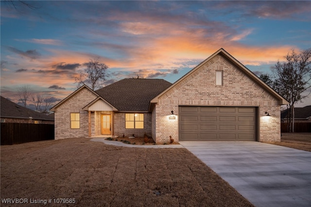 view of front of home featuring fence, concrete driveway, an attached garage, a shingled roof, and brick siding