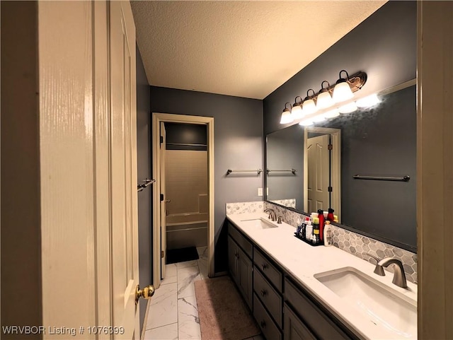 bathroom featuring shower / bathing tub combination, vanity, and a textured ceiling