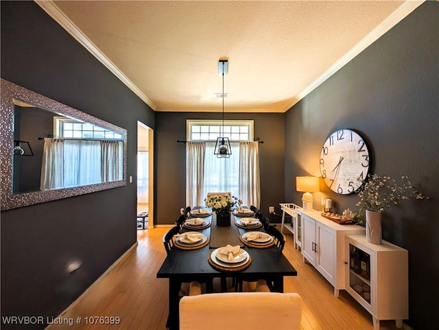 dining space with light wood-type flooring, an inviting chandelier, and crown molding