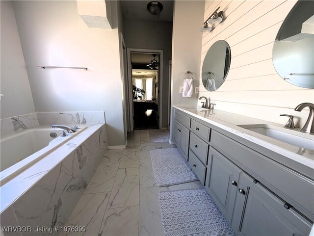 bathroom featuring vanity and a relaxing tiled tub