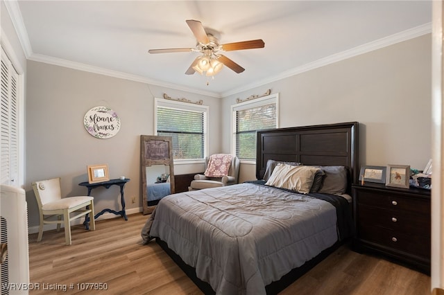 bedroom featuring ceiling fan, ornamental molding, and light hardwood / wood-style flooring