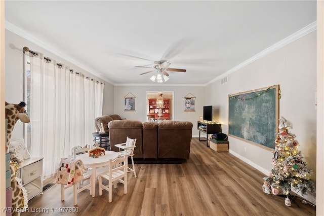 living room with ceiling fan, wood-type flooring, and ornamental molding