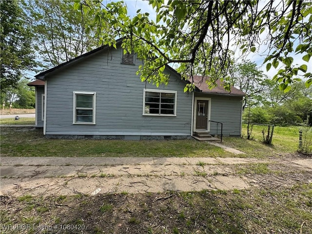 rear view of property featuring crawl space, fence, and entry steps