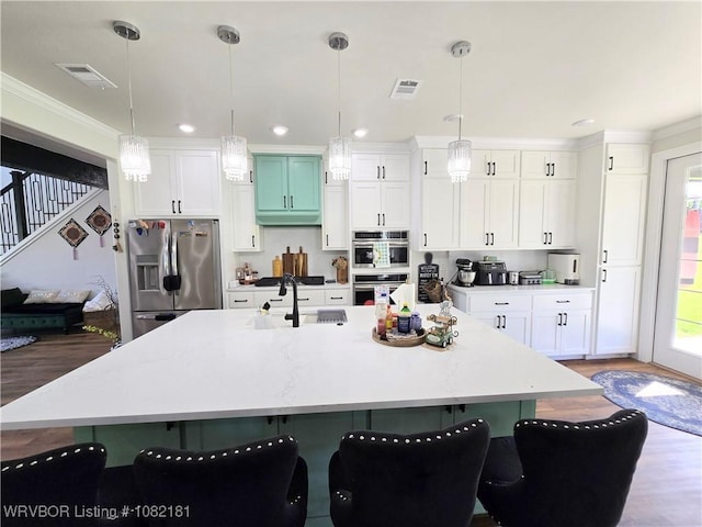 6800 Providence Way, Fort Smith, AR 72916 - kitchen with appliances with stainless steel finishes, a center island with sink, light countertops, wood finished floors, and white cabinets