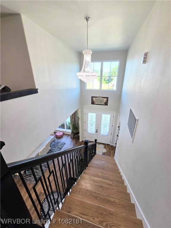 6800 Providence Way, Fort Smith, AR 72916 - stairway with a chandelier, wood finished floors, and a towering ceiling