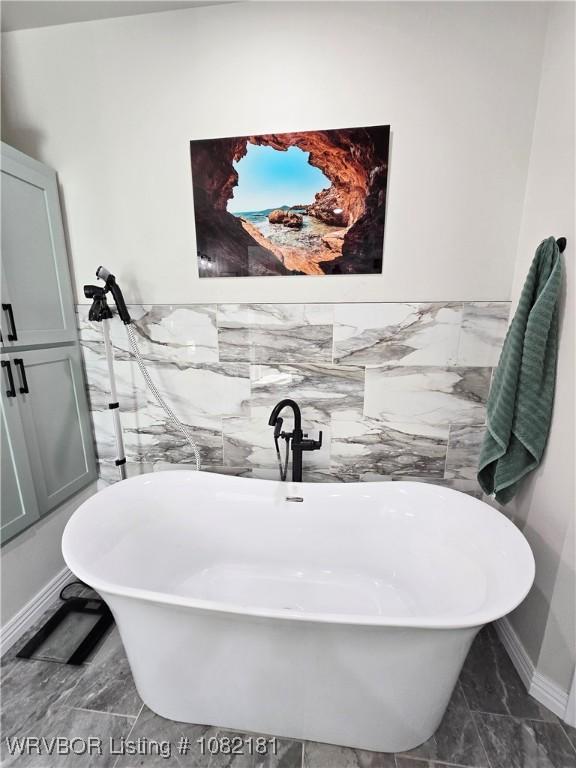 6800 Providence Way, Fort Smith, AR 72916 - bathroom with tile walls, a soaking tub, marble look tile flooring, and a wainscoted wall