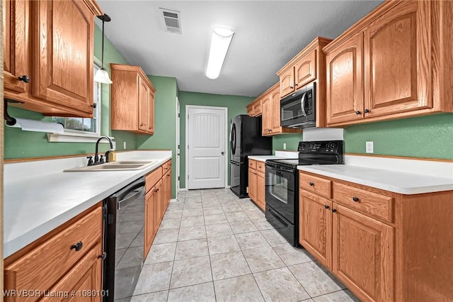 kitchen featuring visible vents, black appliances, light tile patterned flooring, light countertops, and a sink
