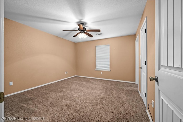 carpeted empty room with visible vents, ceiling fan, baseboards, and a textured ceiling