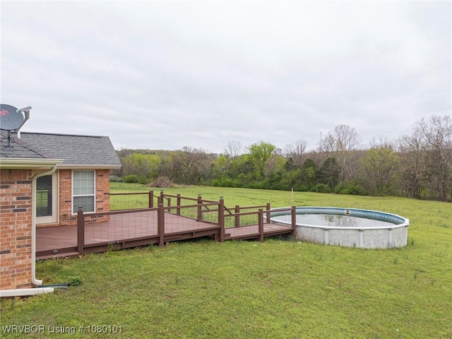 view of yard with a deck and an outdoor pool