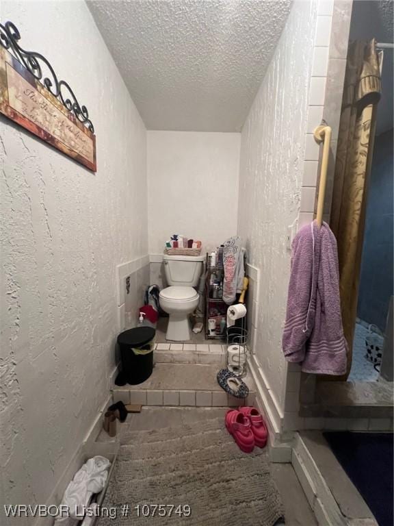 bathroom featuring toilet and a textured ceiling