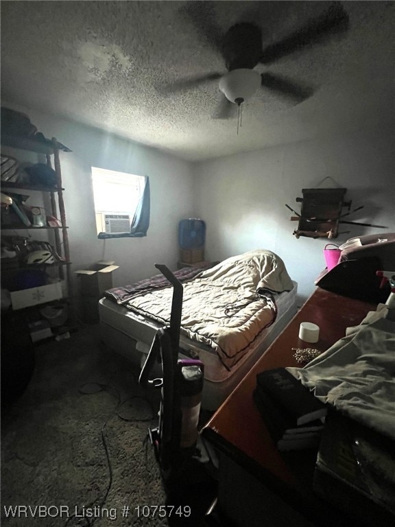 bedroom featuring carpet, ceiling fan, cooling unit, and a textured ceiling