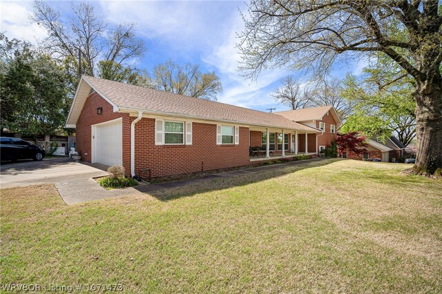 view of side of property featuring covered porch, a garage, and a yard