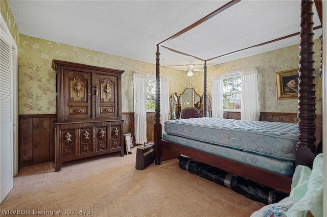 carpeted bedroom featuring a textured ceiling and wood walls