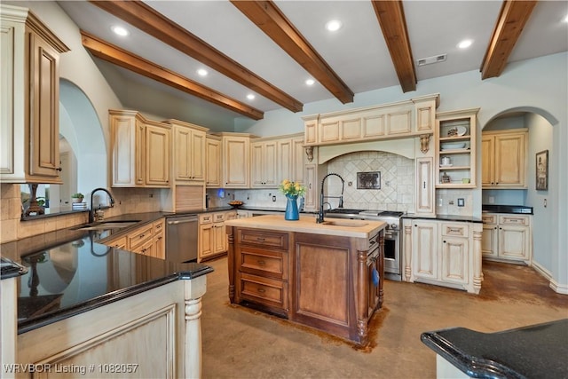 4504 Ridge Rd, Alma, AR 72921 - kitchen with arched walkways, appliances with stainless steel finishes, an island with sink, cream cabinets, and beamed ceiling