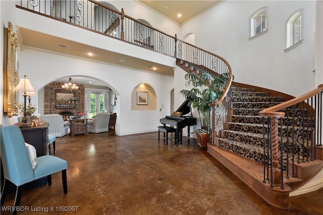 4504 Ridge Rd, Alma, AR 72921 - staircase with arched walkways, concrete floors, a high ceiling, a large fireplace, and ornamental molding
