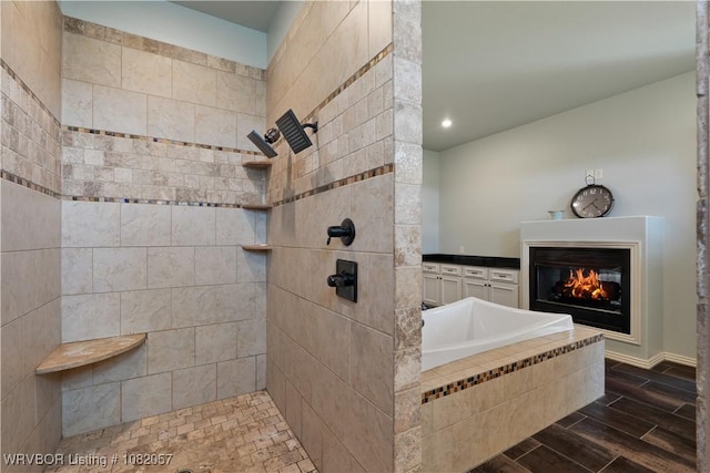 4504 Ridge Rd, Alma, AR 72921 - bathroom with tiled shower, a glass covered fireplace, a bath, wood tiled floors, and recessed lighting