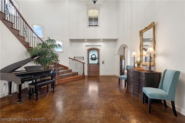 4504 Ridge Rd, Alma, AR 72921 - entrance foyer featuring finished concrete flooring, stairway, arched walkways, and a towering ceiling