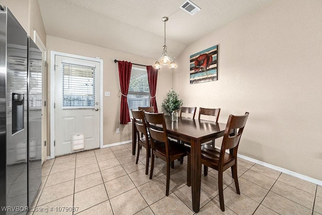 dining space with vaulted ceiling and light tile patterned floors