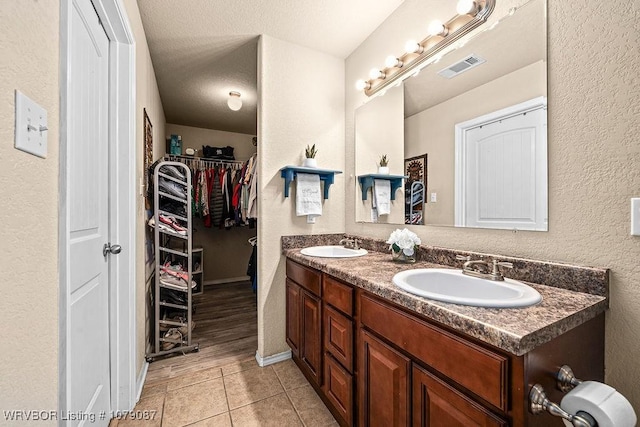 bathroom featuring vanity, a textured ceiling, and tile patterned floors