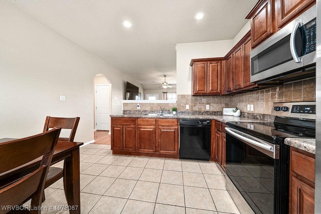 kitchen featuring light tile patterned flooring, sink, stainless steel appliances, and tasteful backsplash