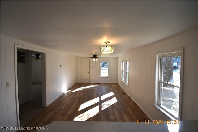 empty room with ceiling fan and dark hardwood / wood-style flooring