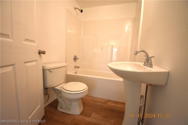 bathroom featuring shower / bathing tub combination, wood-type flooring, and toilet