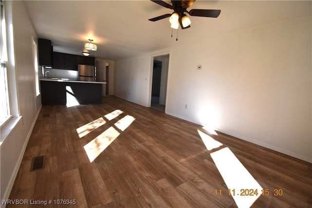 unfurnished living room featuring dark hardwood / wood-style flooring and ceiling fan