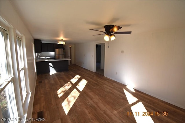 unfurnished living room featuring dark hardwood / wood-style floors, ceiling fan, and a wealth of natural light